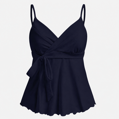 Sleeveless wrap-front peplum cami top with spaghetti straps and adjustable waist tie, styled for elegant everyday wear