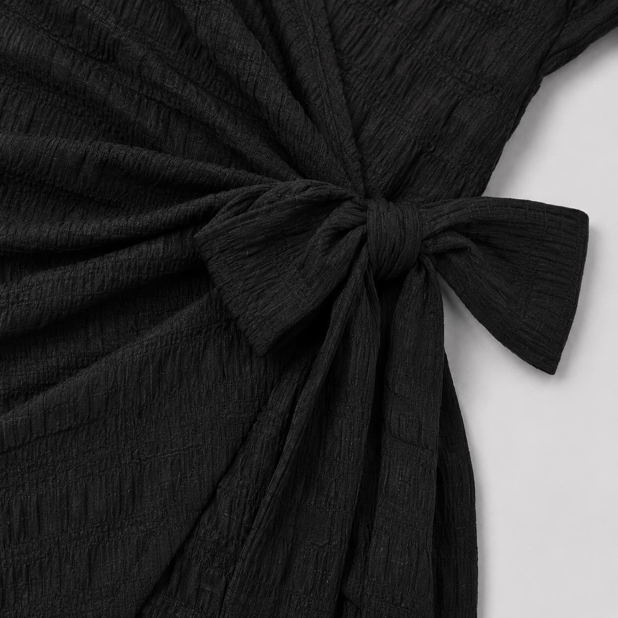 Short sleeve wrap mini dress with surplice V-neckline, side tie waist, and textured fabric