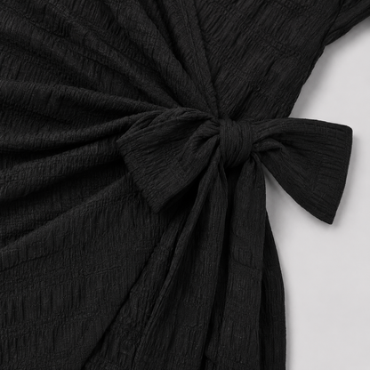 Short sleeve wrap mini dress with surplice V-neckline, side tie waist, and textured fabric